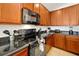 Modern kitchen featuring black appliances, granite countertops, and ample wood cabinets at 410 Viola Dr, Davenport, FL 33837