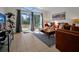 Living room featuring tile flooring, leather seating, stylish artwork, and sliding glass doors to the outdoor pool at 410 Viola Dr, Davenport, FL 33837