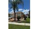 Inviting single-story home with lush landscaping, including a palm tree, and a two-car garage at 105 Cattail Ct, Kissimmee, FL 34743
