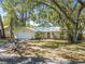 Inviting single-story yellow home with a well-kept lawn, mature trees, and a convenient attached garage at 1432 Mollie Rd, Daytona Beach, FL 32114