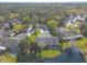 Aerial view of the property backing up to the lake in a lush, wooded neighborhood at 206 Sage Brush Trl, Ormond Beach, FL 32174