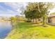 Lush backyard featuring a serene lake view, well-manicured lawn, and mature trees providing shade and privacy at 206 Sage Brush Trl, Ormond Beach, FL 32174