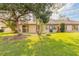 Large backyard features a well-maintained lawn, patio, and mature trees that provide privacy and shade at 206 Sage Brush Trl, Ormond Beach, FL 32174