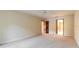 Spacious bedroom with neutral carpeting, ceiling fan, and door leading to hall at 206 Sage Brush Trl, Ormond Beach, FL 32174