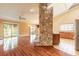 Open-concept living room featuring hardwood floors, natural light, and a unique stone fireplace at 206 Sage Brush Trl, Ormond Beach, FL 32174