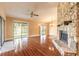 Spacious living room featuring hardwood floors, a cozy stone fireplace, and a view of the backyard pond at 206 Sage Brush Trl, Ormond Beach, FL 32174