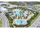 Resort-style pool area with beach entry, tiki huts, lounge chairs, and lush tropical landscaping at 251 Island Breeze Ave, Daytona Beach, FL 32124
