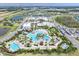 Aerial view of the community resort style pool, tiki bar, and clubhouse with ample parking and lush landscaping at 251 Island Breeze Ave, Daytona Beach, FL 32124