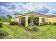 Backyard view featuring yellow home with screened patio and lush landscaping at 251 Island Breeze Ave, Daytona Beach, FL 32124