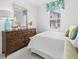 Cozy bedroom with a wooden dresser, white quilt, and floral valance above the window at 251 Island Breeze Ave, Daytona Beach, FL 32124