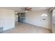 Bright living room features tile floors, a ceiling fan, and a view to the kitchen area at 30 Azalea Dr, Ormond Beach, FL 32176