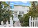 Two story home featuring a picket fence, sidewalk, and well maintained front yard plants and bushes at 322 Garden St, Daytona Beach, FL 32114