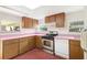 Bright kitchen with stainless steel oven and stove, wood cabinets, and light pink countertops at 322 Garden St, Daytona Beach, FL 32114