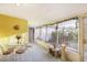 Enclosed porch with white furniture, a decorative wrought iron fence, and views of the yard at 322 Garden St, Daytona Beach, FL 32114