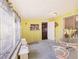 Bright enclosed porch with views of the exterior, yellow walls, and white patio furniture at 322 Garden St, Daytona Beach, FL 32114