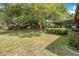 Expansive backyard with mature trees, lush lawn, and partial view of the screened-in porch at 3385 Ne 44Th Pl, Ocala, FL 34479