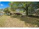Grassy backyard with mature trees and a partial view of the home's exterior at 3385 Ne 44Th Pl, Ocala, FL 34479
