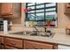 Kitchen with stainless steel sink, wood cabinets and large window at 3385 Ne 44Th Pl, Ocala, FL 34479