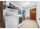 Bright laundry room with white appliances, shelving, storage, and a window at 3385 Ne 44Th Pl, Ocala, FL 34479