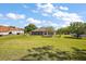 Expansive green backyard with a sunroom addition to the home, with blue skies and scattered trees at 39601 Harbor Hills Blvd, Lady Lake, FL 32159