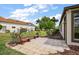 Features a stone patio with flower beds and seating, adjacent to a green lawn and the side of the house at 39601 Harbor Hills Blvd, Lady Lake, FL 32159