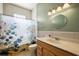Bright bathroom featuring a classic vanity, round mirror, and tiled walls at 39601 Harbor Hills Blvd, Lady Lake, FL 32159