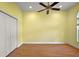 Empty bedroom with yellow walls, hardwood floors, ceiling fan and closet space at 39601 Harbor Hills Blvd, Lady Lake, FL 32159
