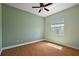 Bedroom with hardwood floors, window, ceiling fan and neutral colored walls at 39601 Harbor Hills Blvd, Lady Lake, FL 32159