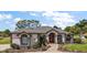 Charming single story home with beautiful landscaping, brick path, and decorative red front door at 39601 Harbor Hills Blvd, Lady Lake, FL 32159