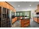 Large kitchen with stainless steel appliances, oak cabinets, granite counters, and center island at 39601 Harbor Hills Blvd, Lady Lake, FL 32159
