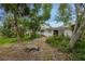 Backyard featuring mature trees, landscaping, and a glimpse of the home's exterior at 59 Amsden Rd, Ormond Beach, FL 32176