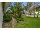 Private backyard featuring a stone path, lush landscaping and mature trees at 59 Amsden Rd, Ormond Beach, FL 32176