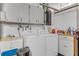 Functional laundry room with washer, dryer, upper cabinets, sink, and storage at 59 Amsden Rd, Ormond Beach, FL 32176