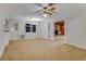 Inviting living room featuring neutral carpet, ceiling fan, and an open layout to a fireplace at 59 Amsden Rd, Ormond Beach, FL 32176