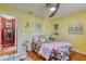 Bright yellow bedroom featuring hardwood floors, floral bedding and coastal themed artwork at 6172 Knotty Pine Ct, Port Orange, FL 32127
