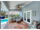 Inviting covered patio with comfortable seating, stylish decor, and view of the screened-in pool area at 6172 Knotty Pine Ct, Port Orange, FL 32127