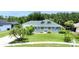 Charming single-story home with a well-manicured lawn, mature palm trees, and a welcoming front porch at 6172 Knotty Pine Ct, Port Orange, FL 32127