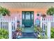 Inviting front porch with a cozy welcome mat, potted plants, hanging ferns, and nautical décor at 6172 Knotty Pine Ct, Port Orange, FL 32127