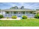 Inviting front porch with a decorative glass door, ferns, and manicured landscaping at 6172 Knotty Pine Ct, Port Orange, FL 32127