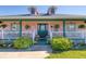 Charming pink home featuring a welcoming front porch with a white picket fence and lush landscaping at 6172 Knotty Pine Ct, Port Orange, FL 32127