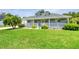 Attractive single-Gathering home featuring a manicured lawn, mature trees, and a classic white picket fence at 6172 Knotty Pine Ct, Port Orange, FL 32127