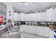 Kitchen featuring a stainless steel sink, breakfast bar seating and white cabinets at 6172 Knotty Pine Ct, Port Orange, FL 32127