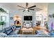 Comfortable living room featuring a large blue leather sofa and modern ceiling fan at 6172 Knotty Pine Ct, Port Orange, FL 32127