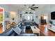 Spacious living room with a large blue sectional, hardwood floors, and a ceiling fan at 6172 Knotty Pine Ct, Port Orange, FL 32127