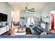 Spacious living room with a vaulted ceiling, a ceiling fan, and a comfortable blue sectional sofa at 6172 Knotty Pine Ct, Port Orange, FL 32127