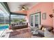 Relaxing screened-in patio featuring comfortable seating and overhead fan with a view of the pool at 6172 Knotty Pine Ct, Port Orange, FL 32127