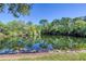 Picturesque pond with calm waters reflecting the surrounding lush trees and blue sky at 6172 Knotty Pine Ct, Port Orange, FL 32127