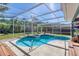 Screened pool enclosure featuring a sparkling pool, spa, and lush outdoor views at 6172 Knotty Pine Ct, Port Orange, FL 32127