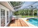 Outdoor living space showcasing a screened pool area with a covered deck, table and chairs, and inviting pool at 6172 Knotty Pine Ct, Port Orange, FL 32127