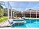 Relaxing pool with screen enclosure, tile detail, and sun loungers for luxurious outdoor enjoyment at 6172 Knotty Pine Ct, Port Orange, FL 32127
